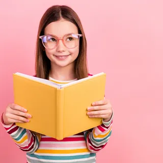 Schulmäden mit Brille und Buch in der Hand