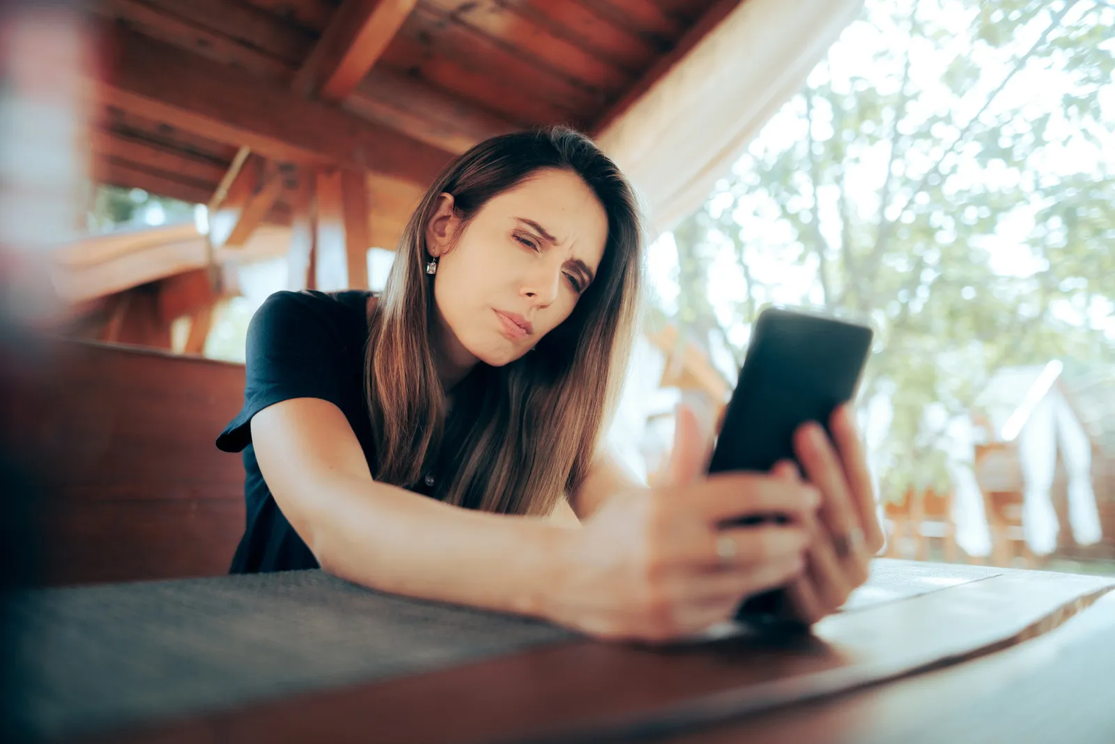 Frau mittleren Alters versucht kleinen Text auf Smartphone zu lesen