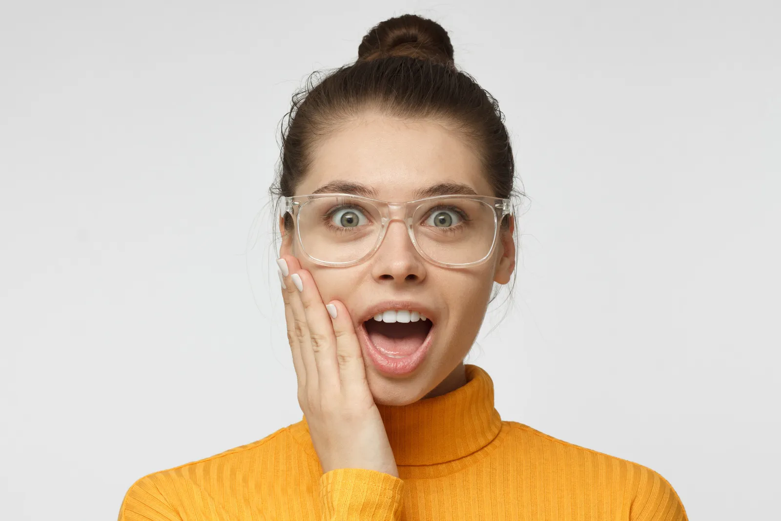 Porträt junge Frau mit transparenter Brille ist erstaunt-