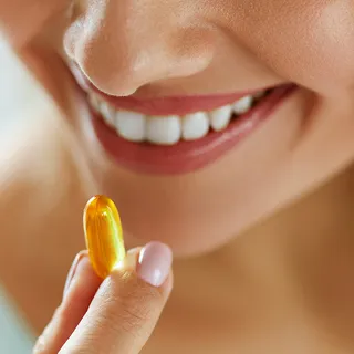 Close Up junge hübsche Frau nimmt eine Omega-3- Kapsel