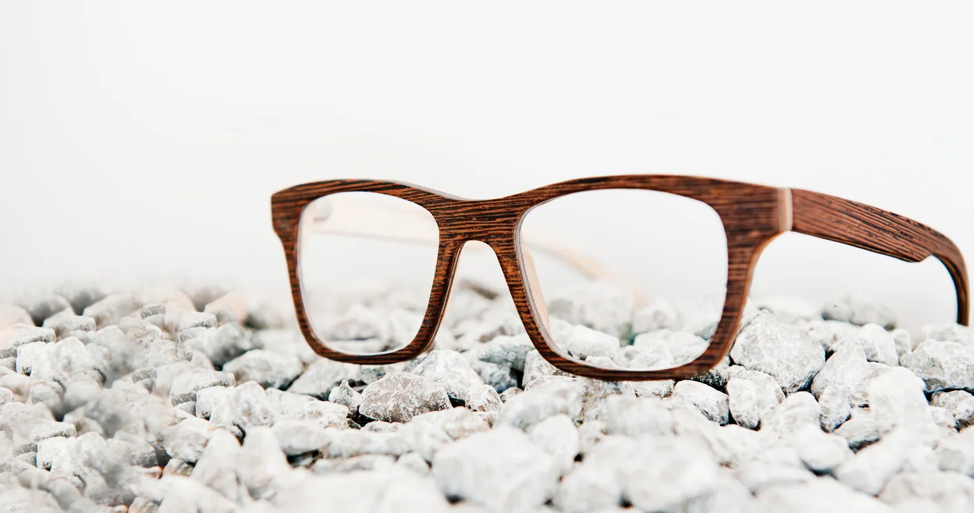 Holzbrille auf weissen Steinen